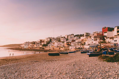 Colorful fishing boats resting on the white sands of a vibrant coastal village