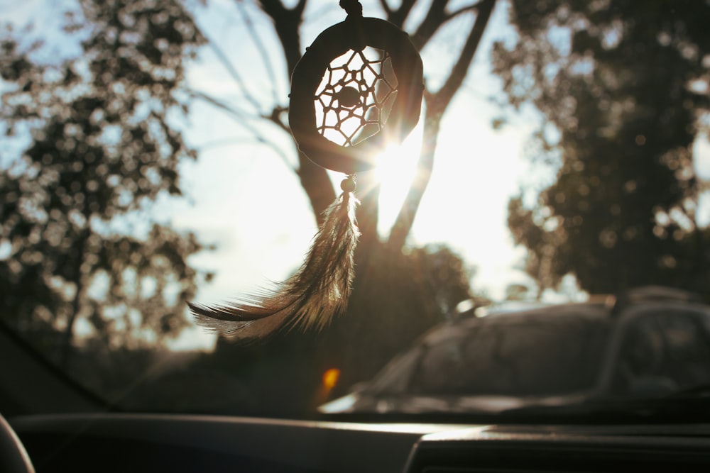 brown dreamcatcher above vehicle dashboard