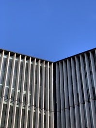 Modern building facade showcasing glass and aluminum elements under clear sky.