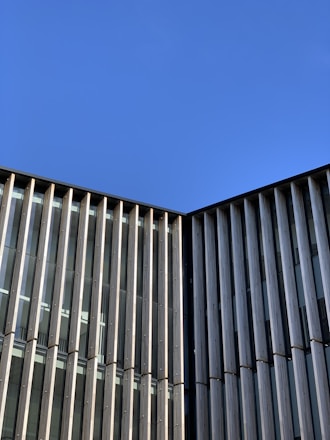 Modern building facade showcasing glass and aluminum elements under clear sky.