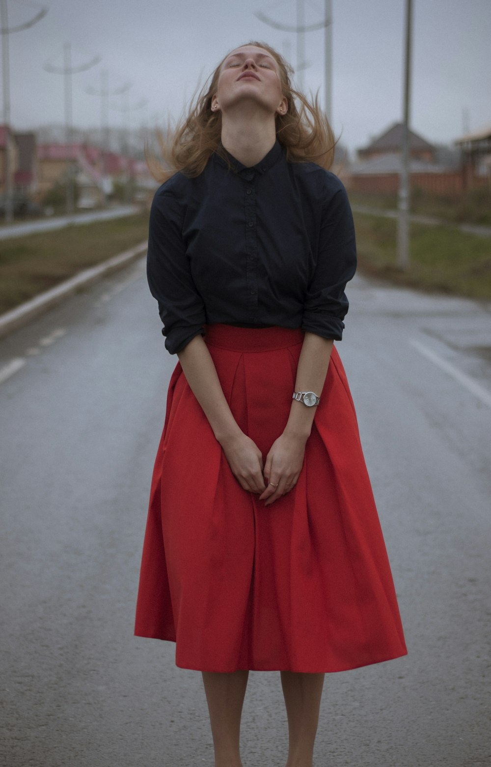 검은 드레스 셔츠와 빨간 긴 치마를 입고 있는 여자