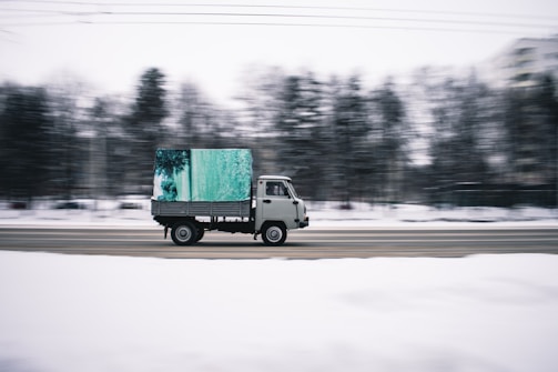 time lapse photography of white cab forward truck surrounded by snow
