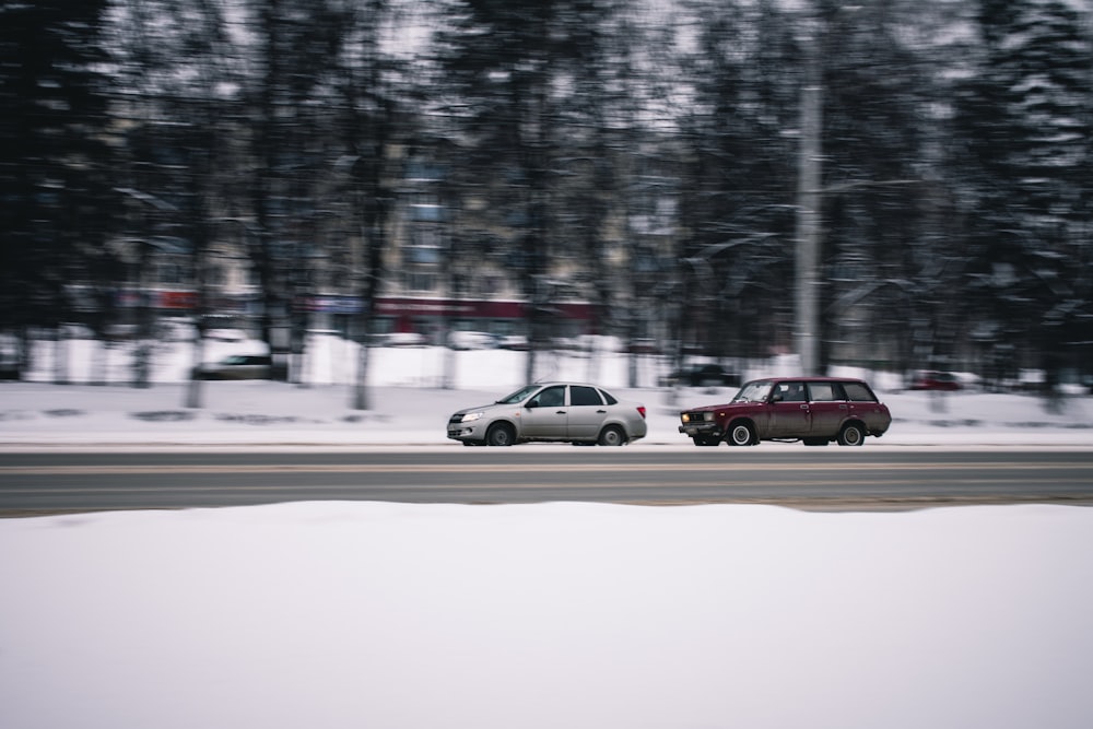 two cars on road surrounded by trees