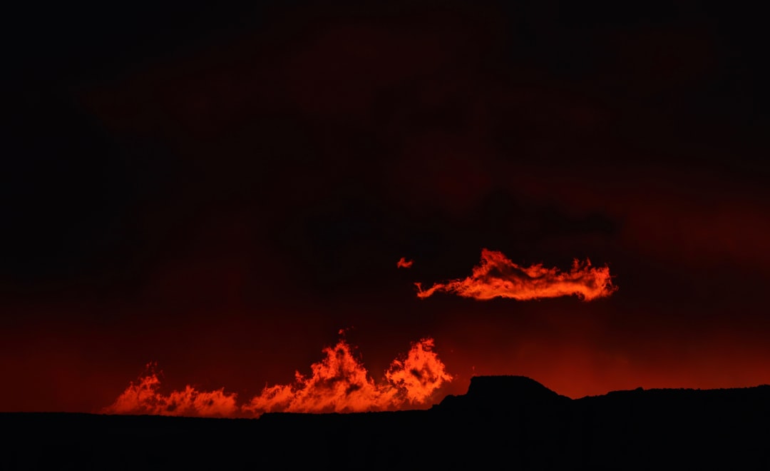 crimson clouds over silhouette of hills, This burning sky at the Horseshoe Bend was not a perfect sunset. I noticed a little detail on the horizon and I took some pictures with my telephoto lens. It was so small, not everybody noticed it.<p></figure>These clouds are lit up by the sun. In this brief moment I captured this amazing detail at the horizon.