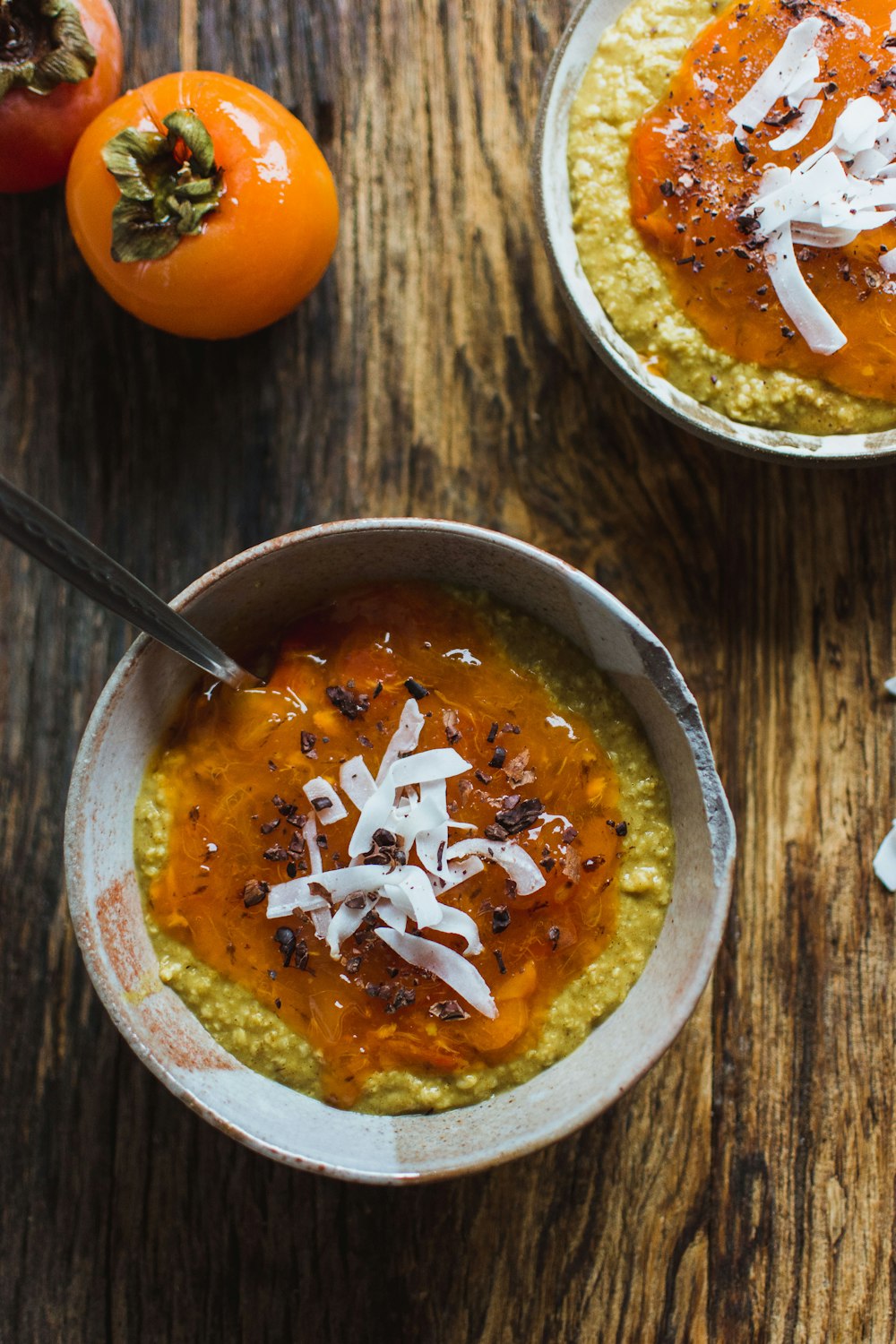 porridge on bowl beside persimmon
