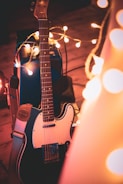 An acoustic guitar leaning against an amplifier in a cozy studio.