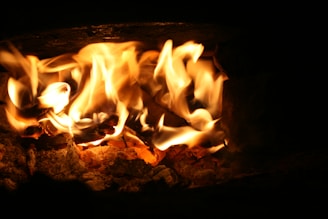 A close-up of a glowing green flame flickering against a dark industrial backdrop, symbolizing ignisoak advisory’s focus on sustainable thermal systems.