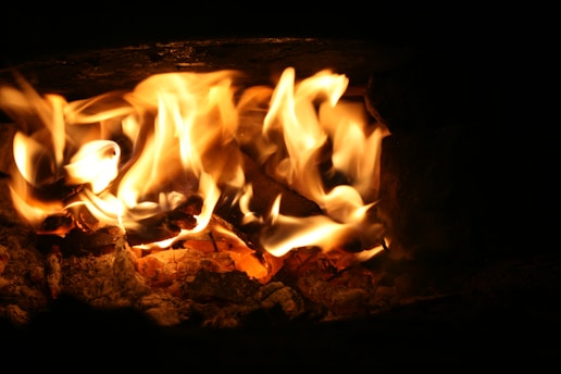 A close-up of a glowing green flame flickering against a dark industrial backdrop, symbolizing ignisoak advisory’s focus on sustainable thermal systems.