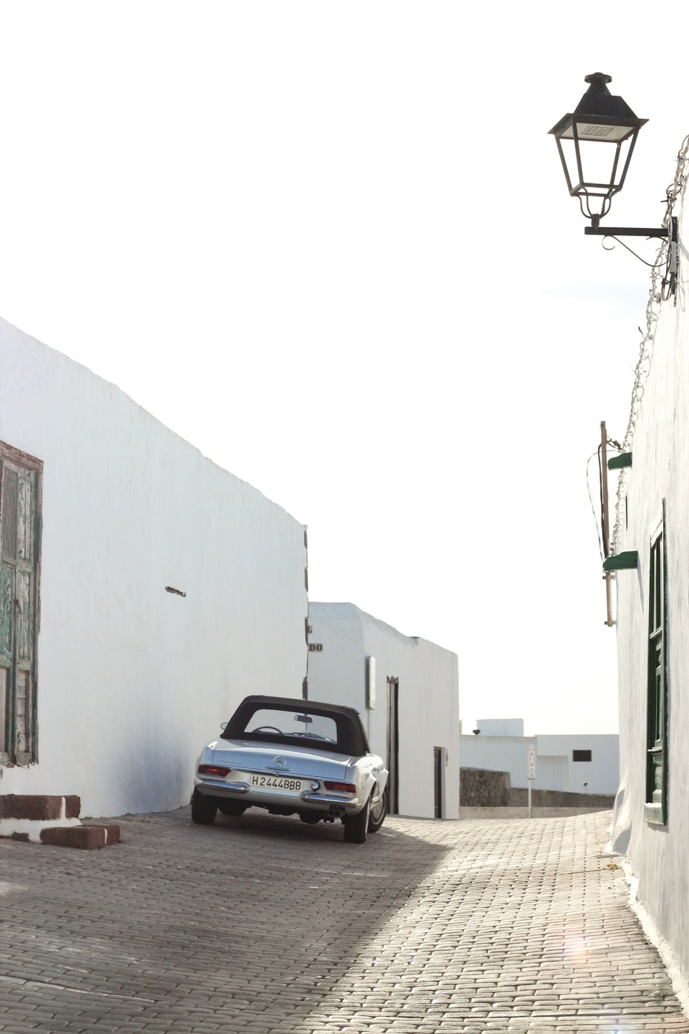 silver car parked beside white building