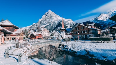 houses covered with snow near the mountain during daytime