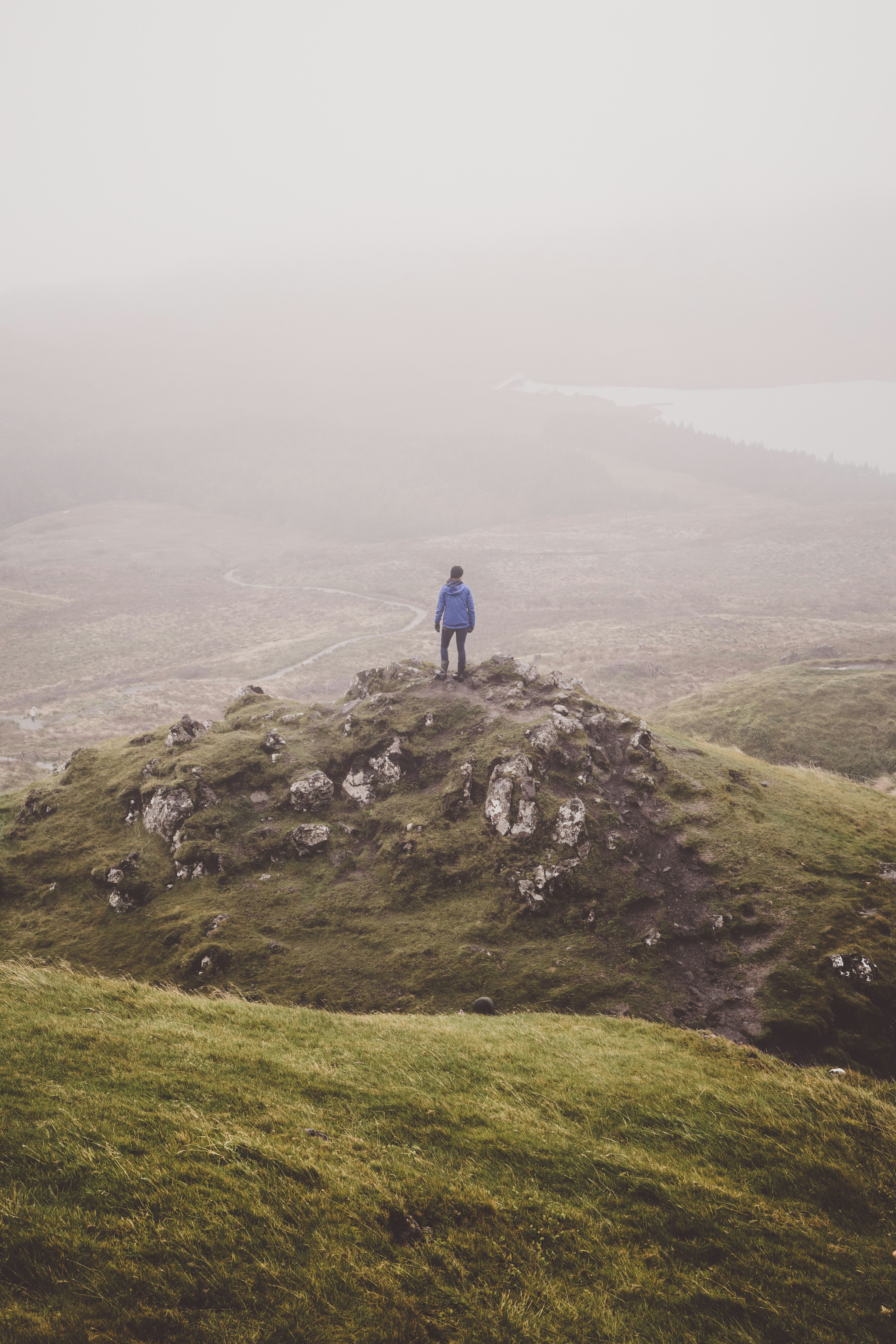 person standing on green hill during daytime