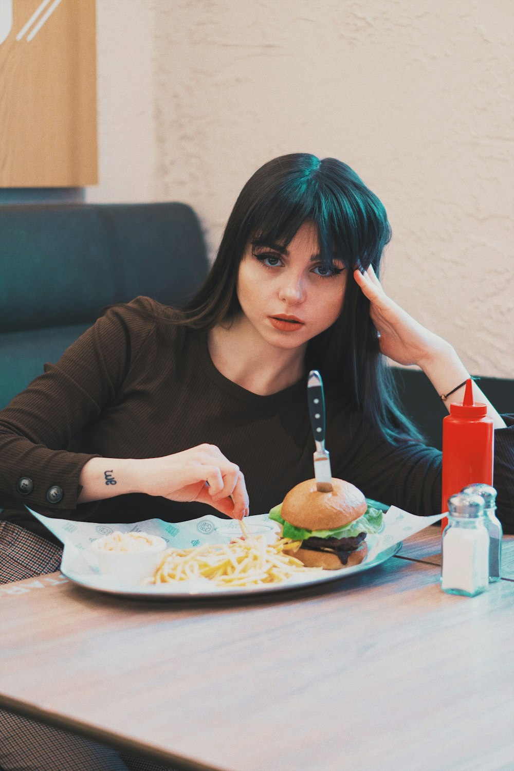 Frau sitzt vor Tablett mit Essen