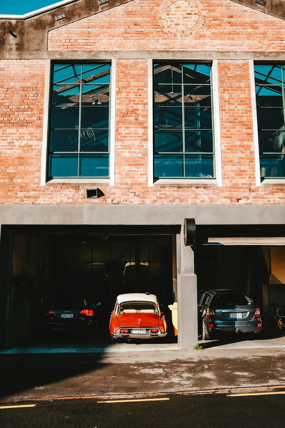 assorted-color vehicles inside brown concrete building