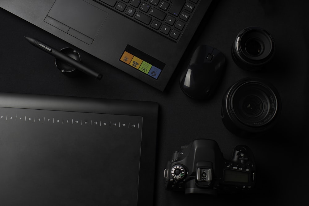 black DSLR camera besides computer mouse