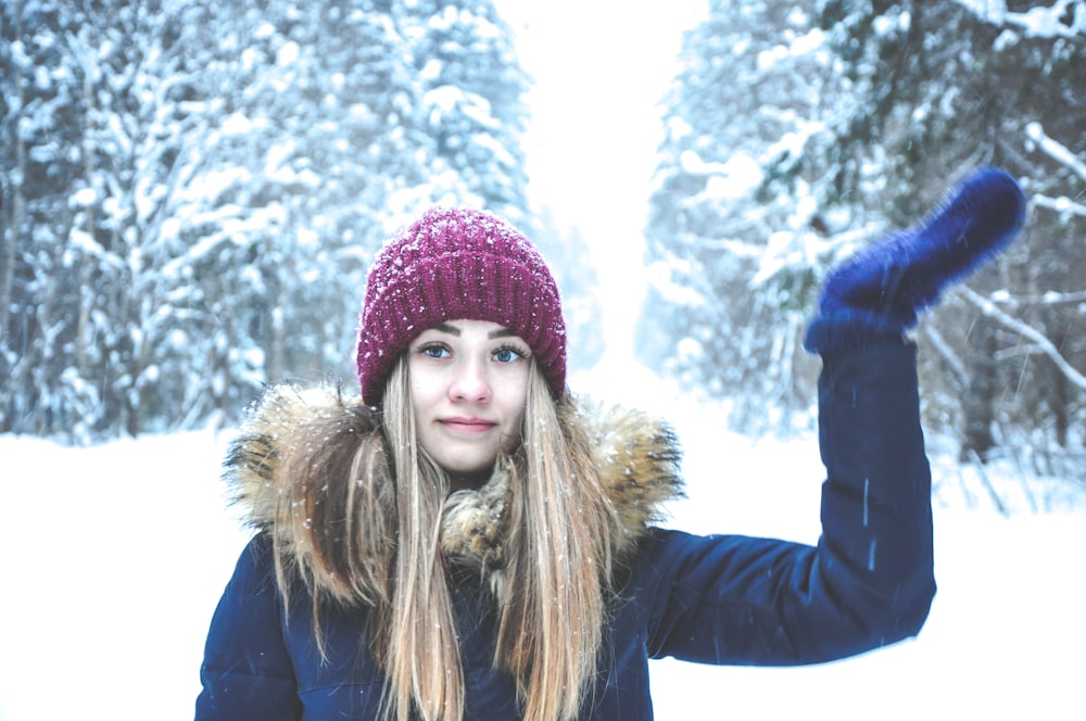 woman wearing knit cap, jacket, and gloves