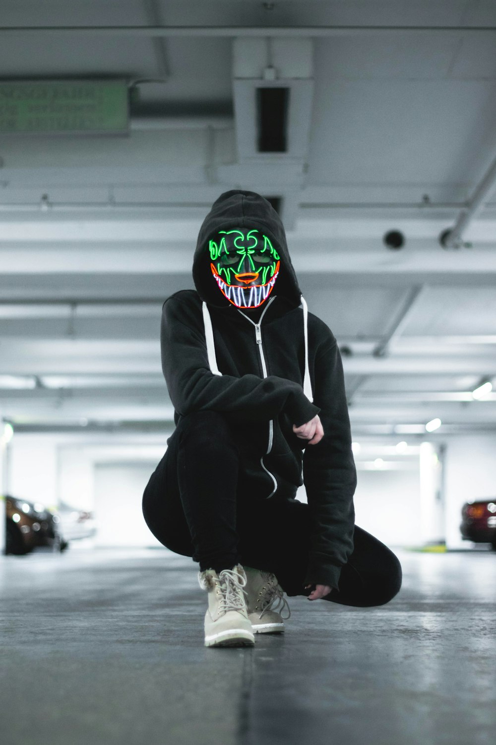 person wearing black zip-up hoodie and mask