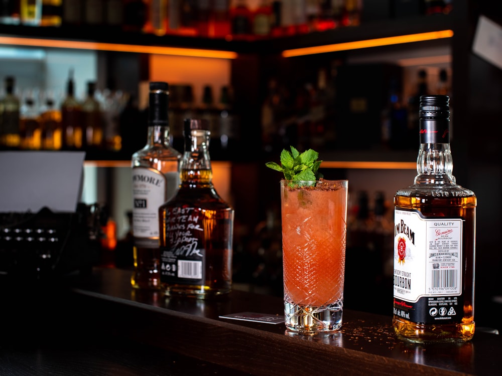 tre bottiglie di liquore e cocktail sul bancone del bar
