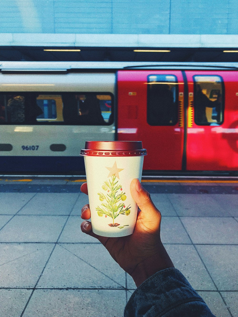 person holding white and brown disposable cup