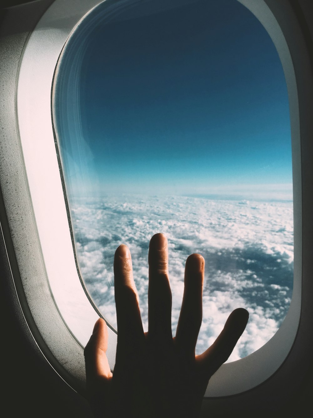 person's hand on planes window