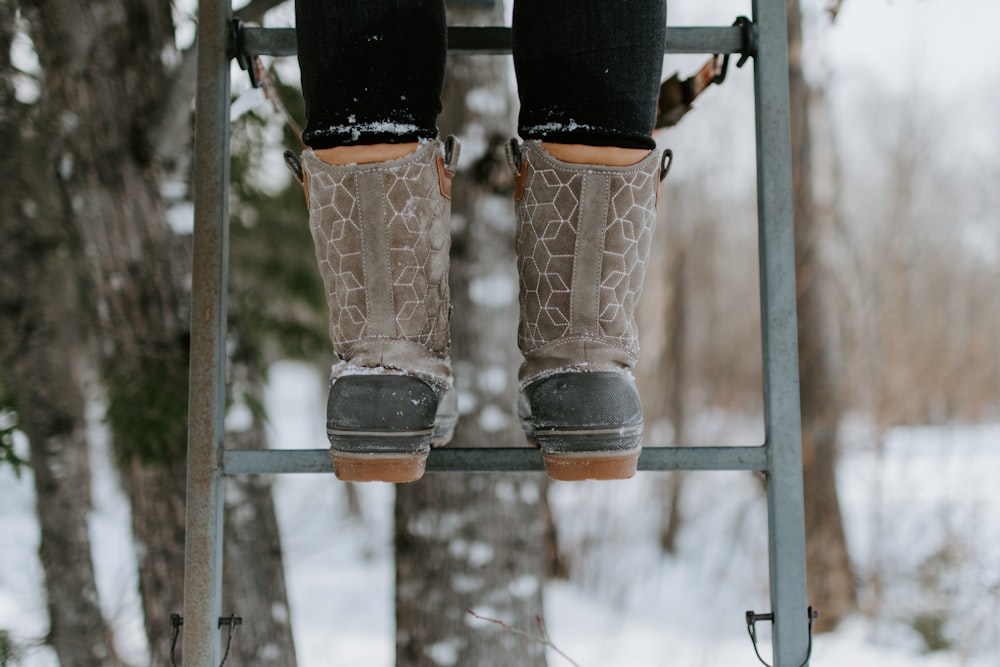 person wearing boots standing on ladder