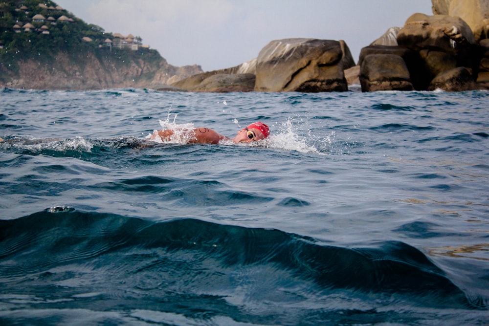 man swimming in sea during daytime