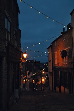 A dimly lit Sicilian village street at dusk, evoking the mood of Verga's stories.