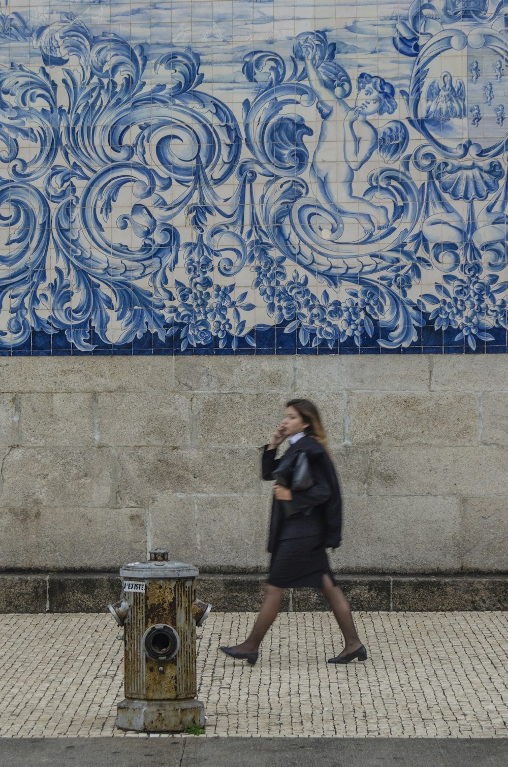 woman walking on sidewalk during daytime