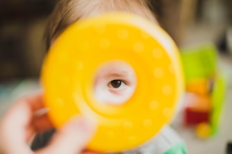 person holding round yellow toy