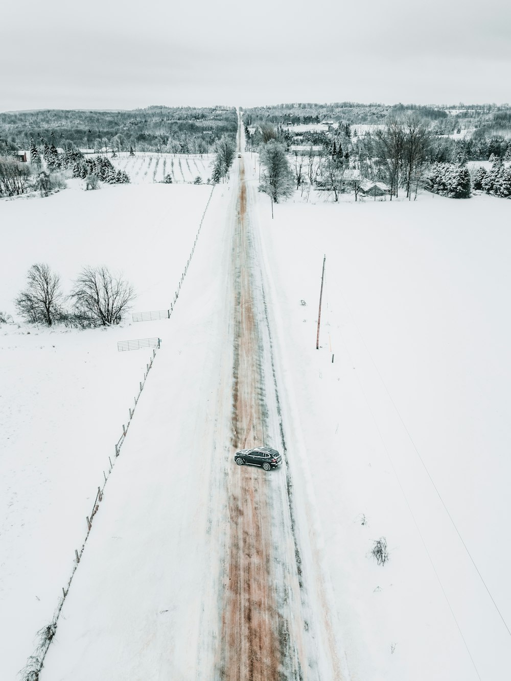 road in between snow covered ground at daytime