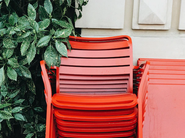 Colorful plastic chairs stacked neatly in a bright room.