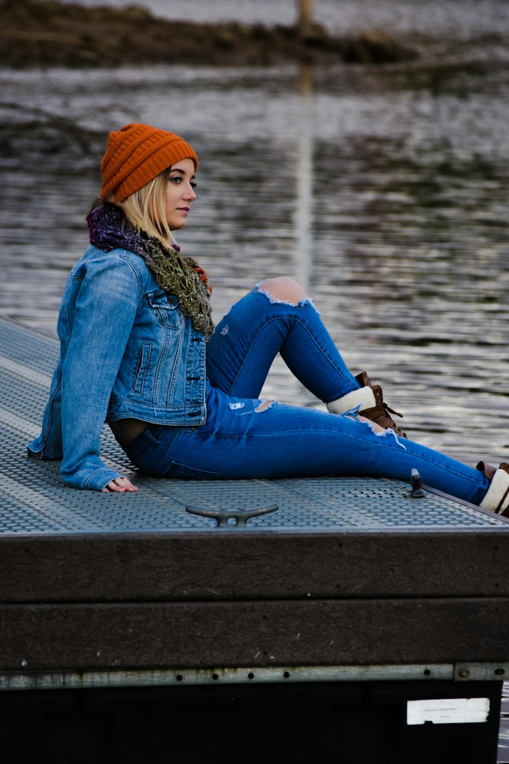 selective focus photography of woman sitting on dock