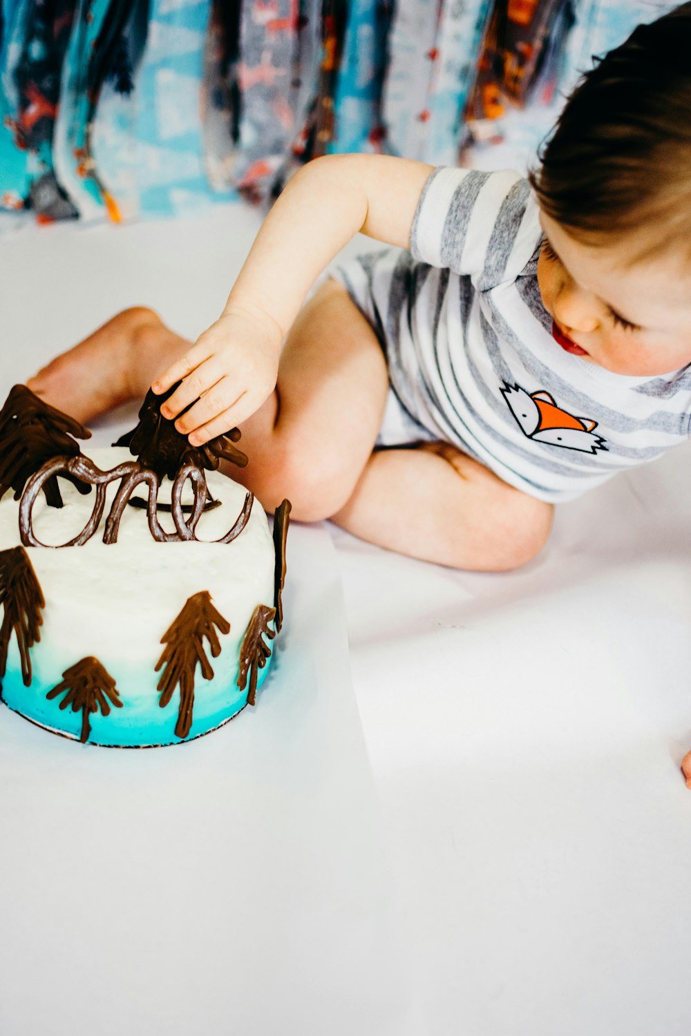 boy lying on floor near cake