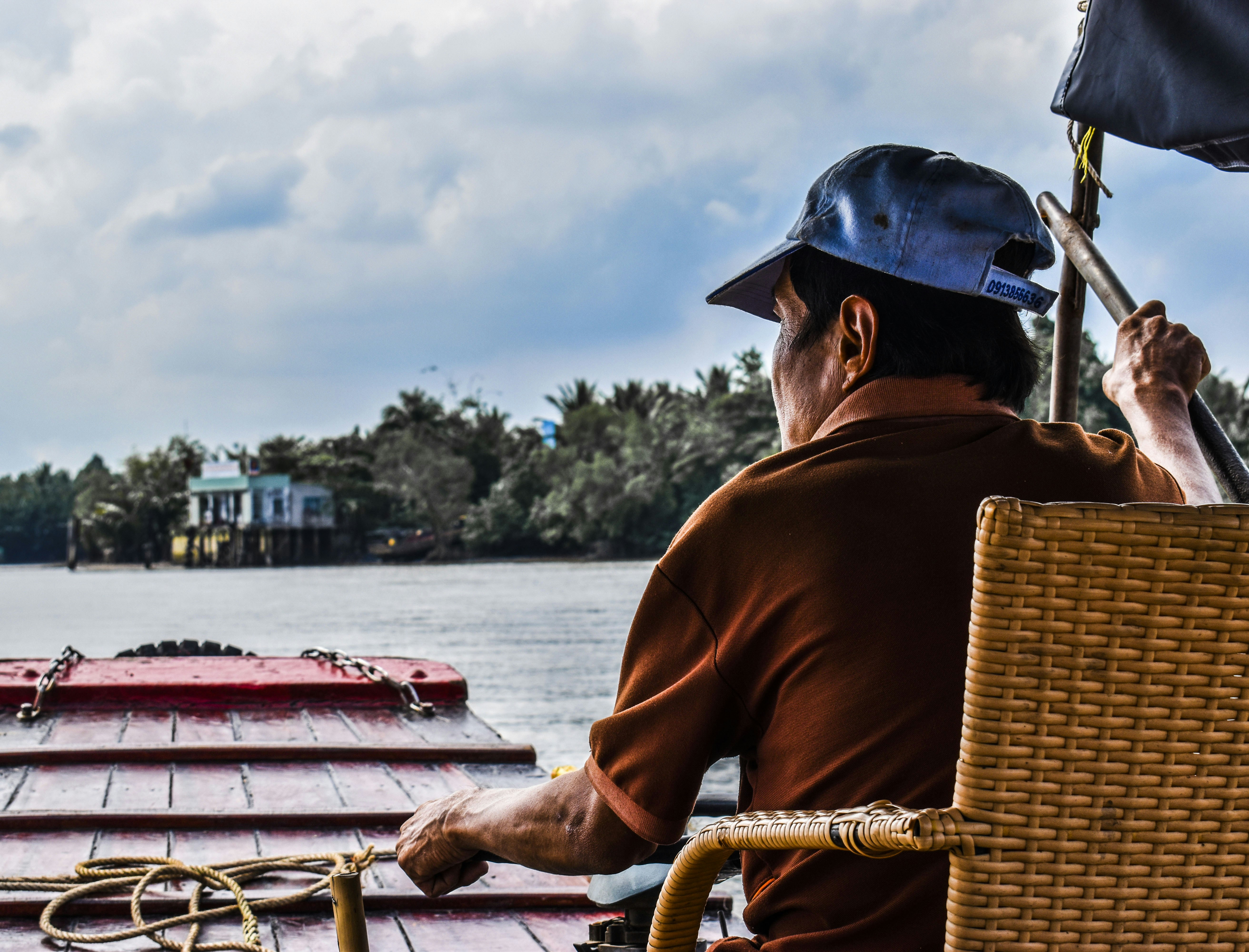 man sitting on wicker chair on boat