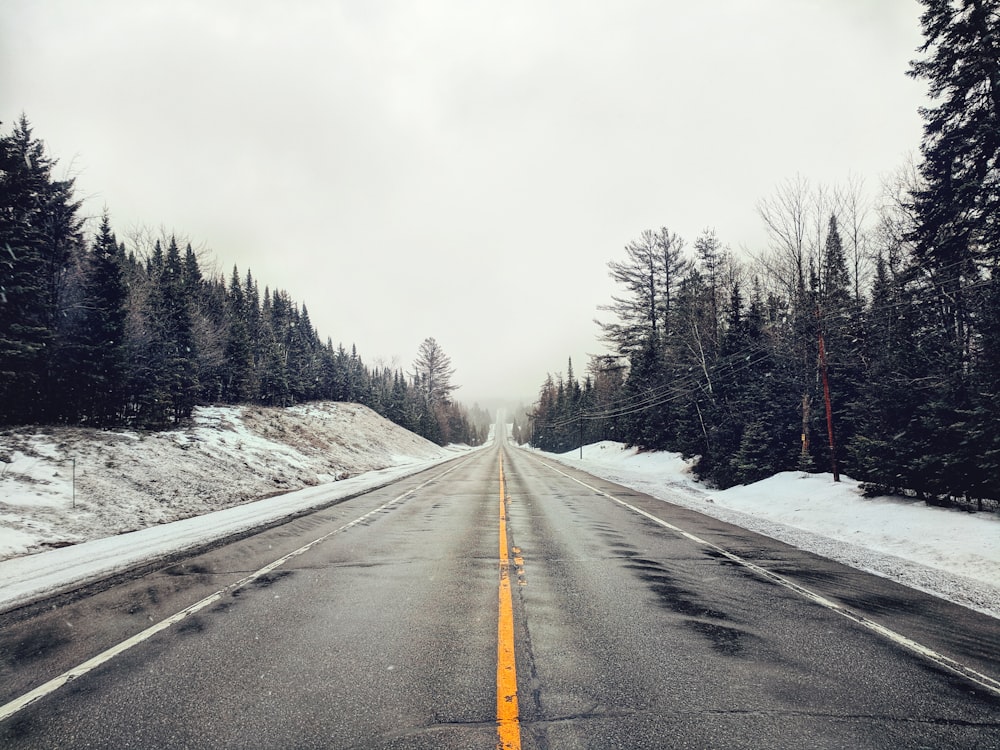 leere Straße mit schneebedeckten Feldern am Rand