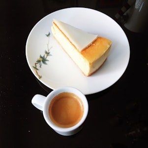 Elegant black and white photo of a cheesecake on a minimalist plate with subtle shadows.