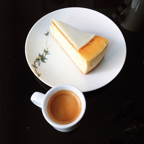 Elegant black and white photo of a cheesecake on a minimalist plate with subtle shadows.