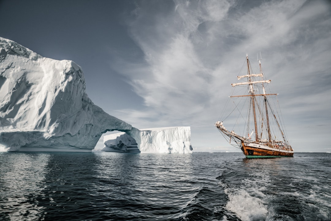 brown boat near glacier during daytime