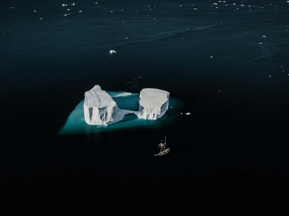 boat by icebergs at sea during daytime