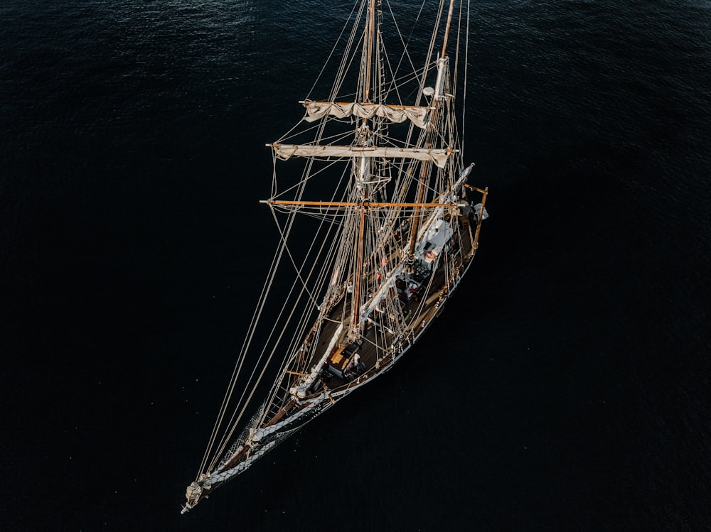 boat with unwinded sails at sea during daytime