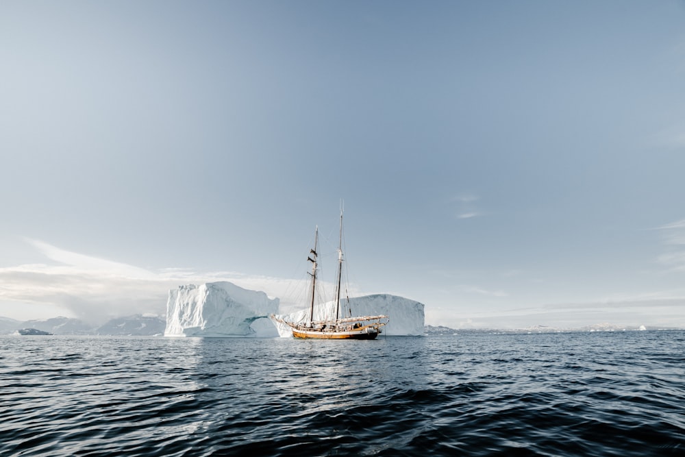 boat on calm body of water near ice bergs