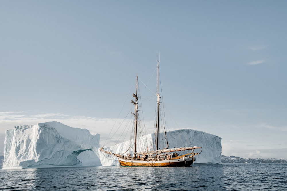Barca marrone vicino all'iceberg durante il giorno
