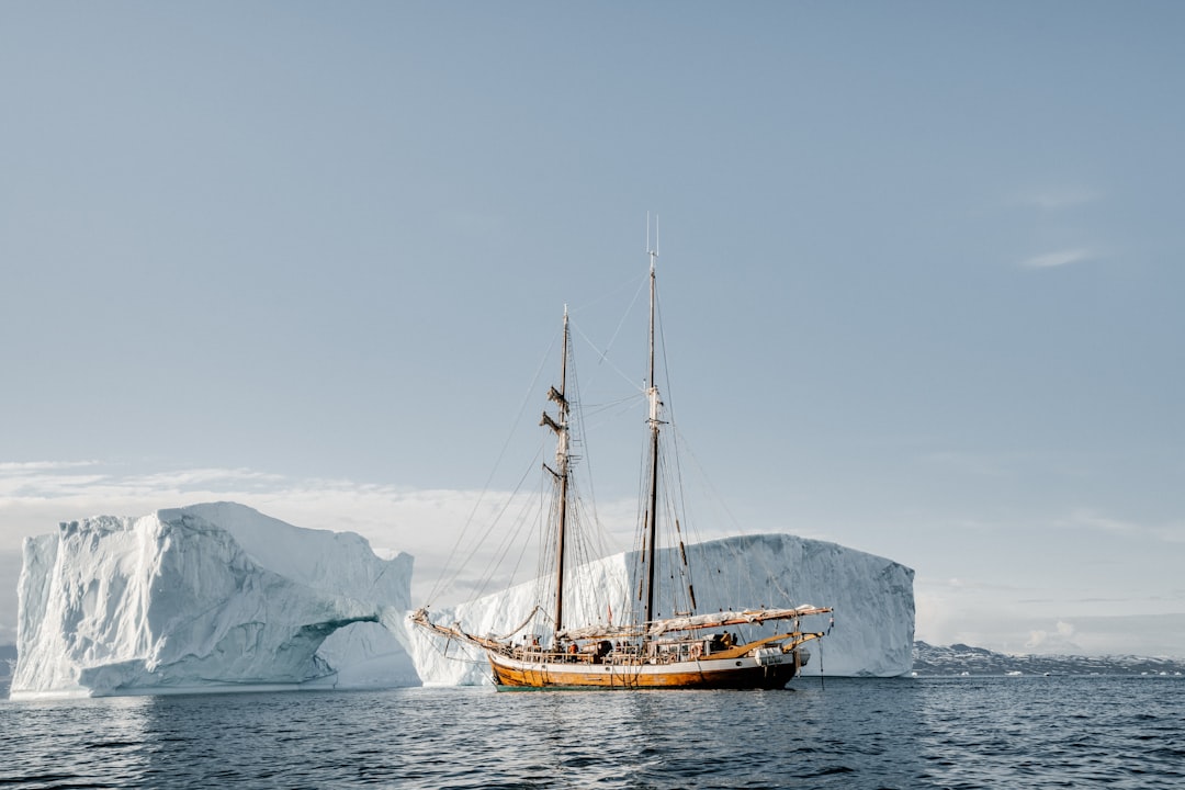 brown boat near ice berg during daytime