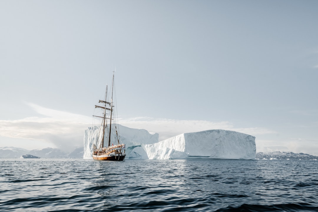 boat near glacier during daytime