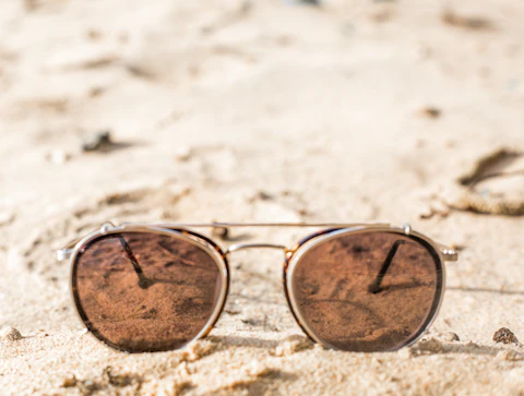 Sunglasses resting on warm sand