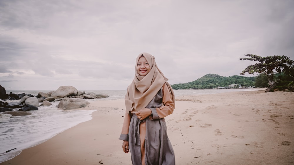 smiling woman wearing hija standing on seashore