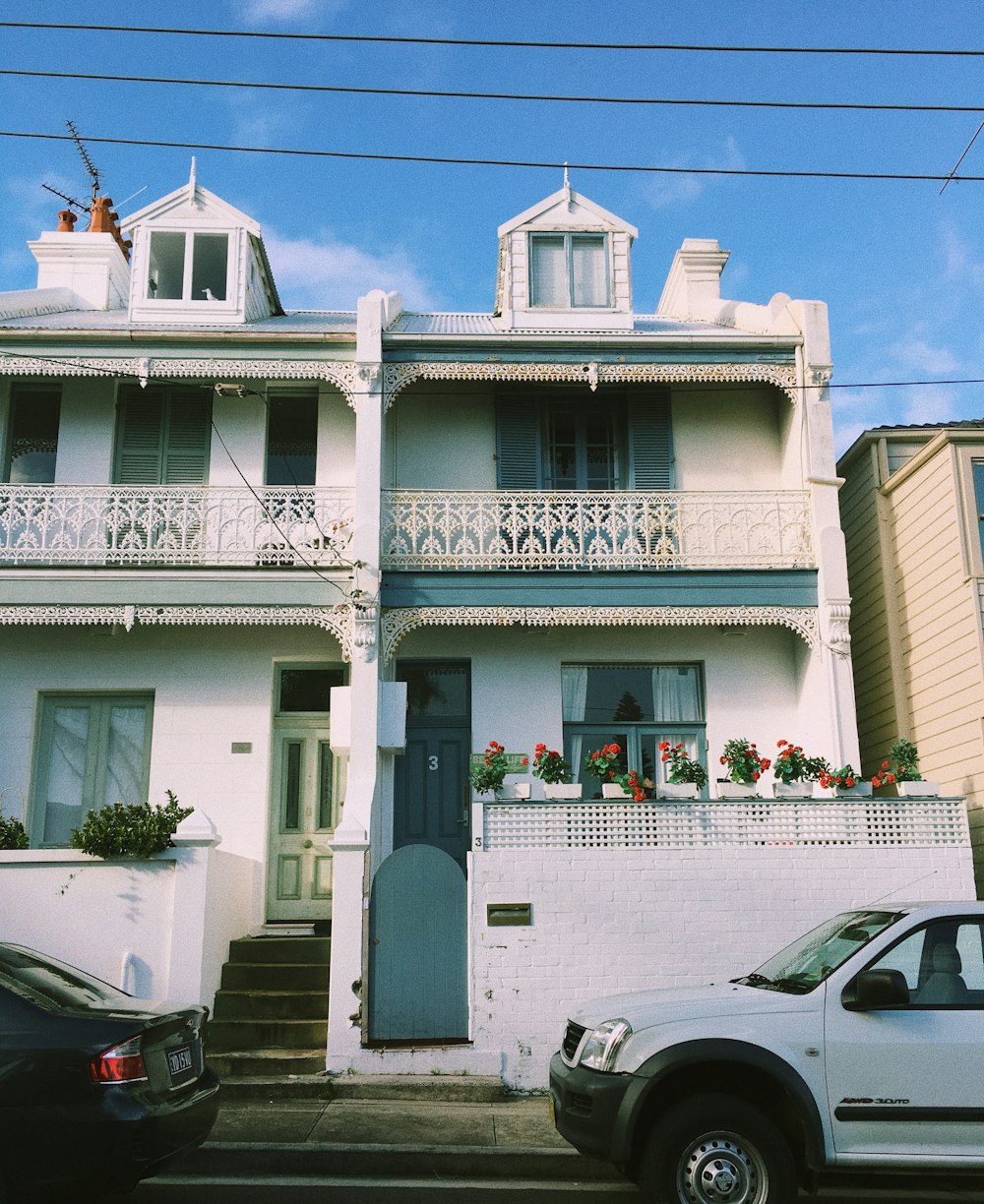 white and black vehicles parked outside white concrete house