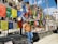 A smiling traveler standing in front of a colorful Bhutanese monastery with prayer flags fluttering in the breeze.