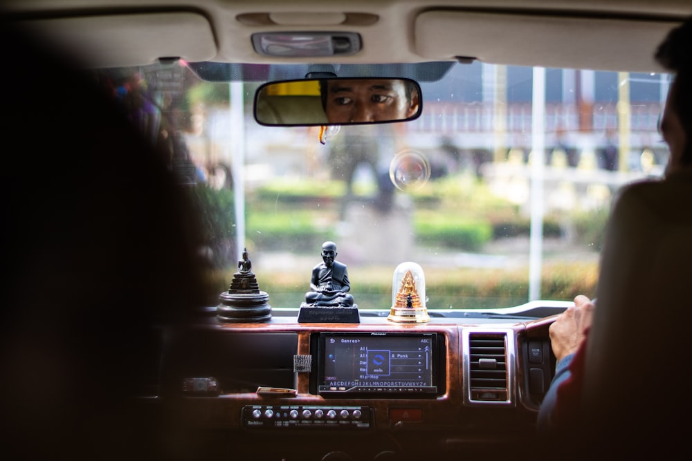 reflection of man's face in vehicle rearview mirror