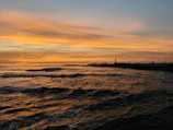 A scenic view of the breakwall with gentle waves and a soft evening sky, perfect for wedding photos.