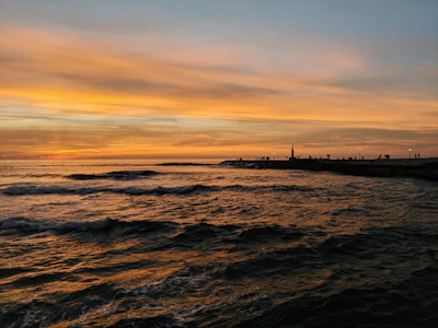 A scenic view of the breakwall with gentle waves and a soft evening sky, perfect for wedding photos.